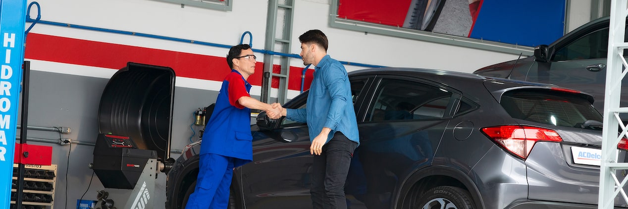 Mecânico da Acdelco e cliente apertando as mãos