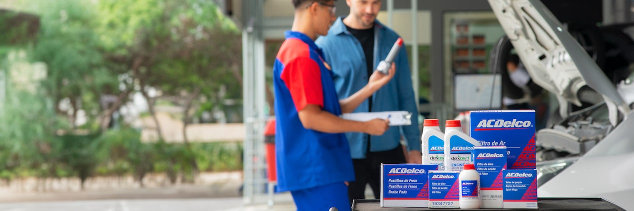 Mecânico mostrando um dos produtos Acdelco para um cliente